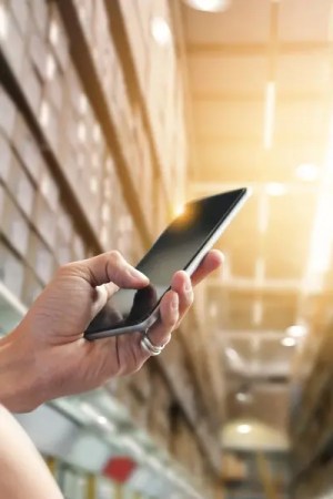 Warehouse worker using phone to check facility.