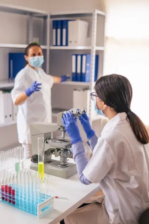 Researchers in a laboratory analyzing test tubes.