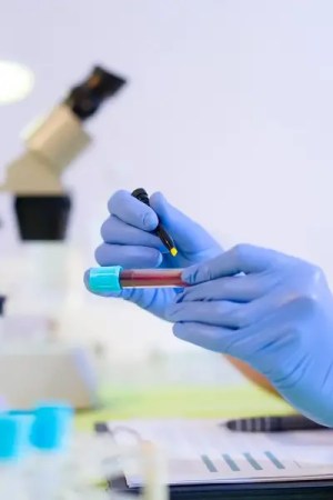 Researcher in a laboratory evaluating test tubes and labeling them.