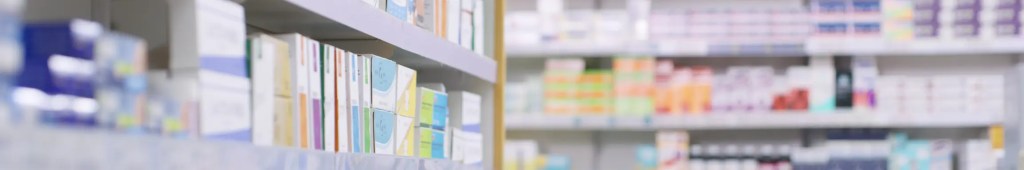 Pharmacy pill boxes lined up on shelves with GRMA certification.