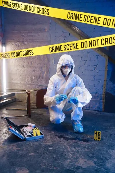 Expert analyzing crime scene for forensics analysis in a lab.