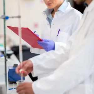 Researchers in a laboratory taking notes.