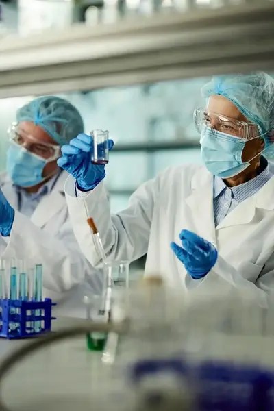 Researchers in a laboratory adhering to ISO/IEC 17043.