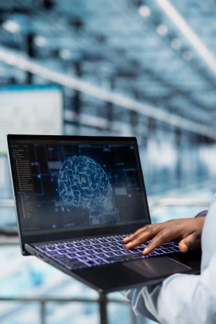 ANAB AI Management Systems Certification: Understanding Person in factory logging into computer to take ISO/IEC 42006 training Course.