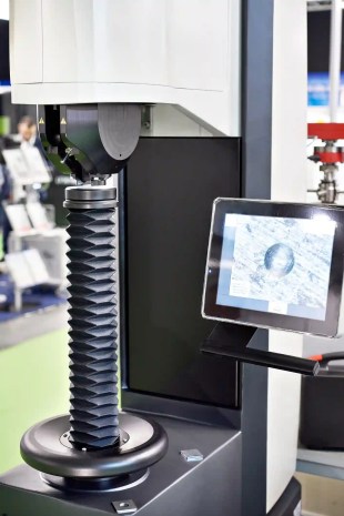 Steel calibration weight placec on the analytical balance. Concept of quality control in a laboratory.
